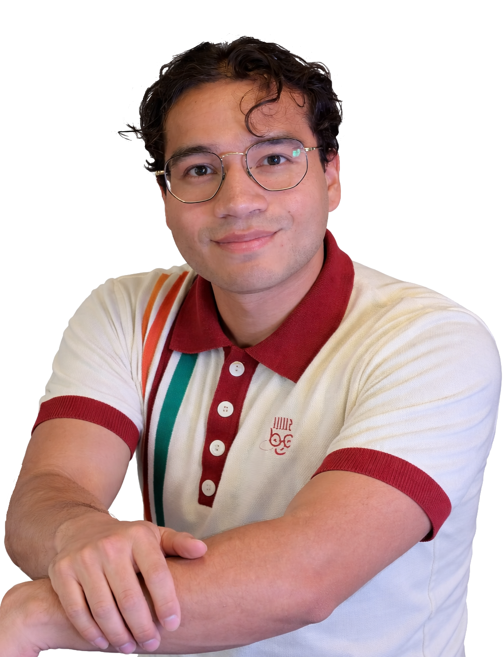 Manuel Guerrero leaning on a side and smiling softly while looking at the camera with his right arm on top of the other one